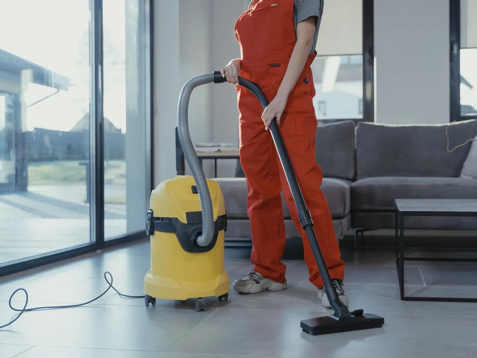 Professional cleaner using commercial equipment in a modern living room.